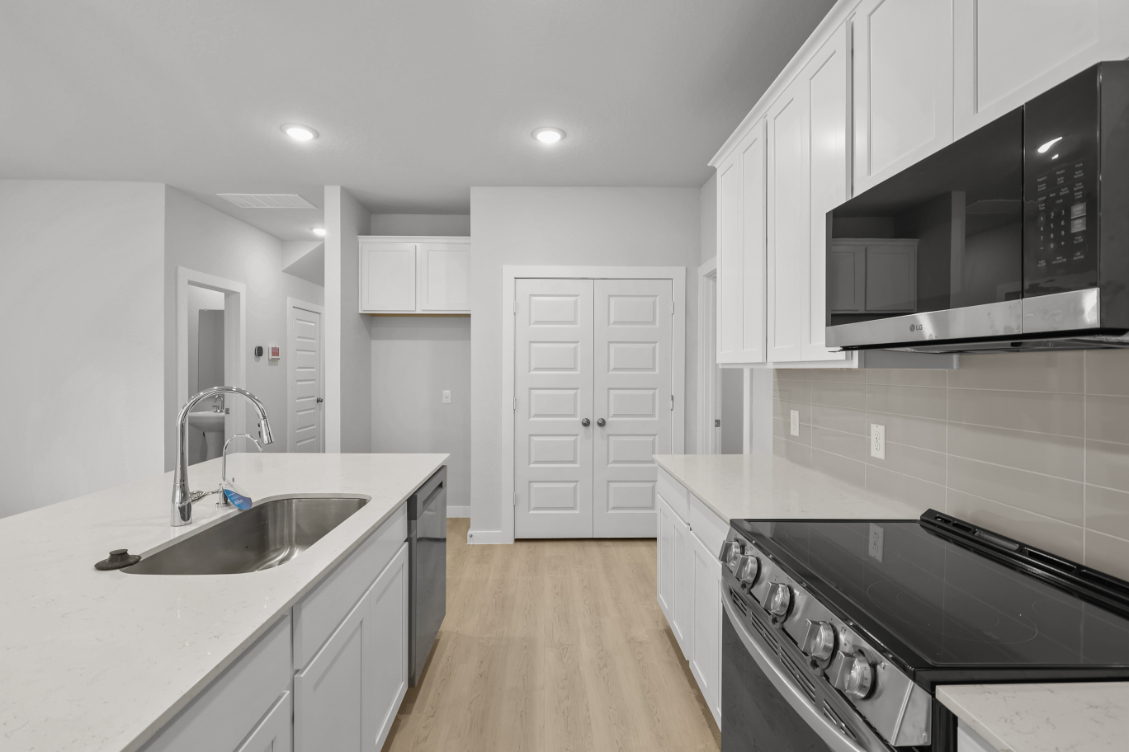 A kitchen with white cabinets.