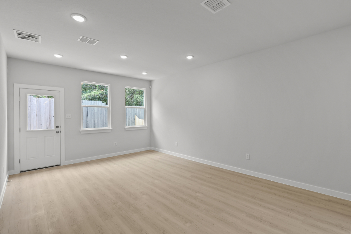 A room with a wood floor and white walls.