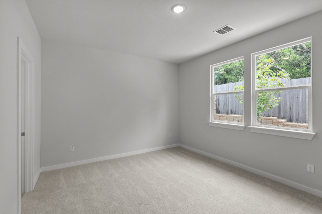 A room with a window and a carpet.