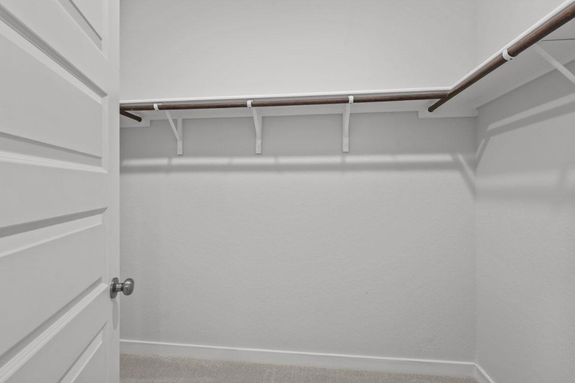 A white wall with a metal bar.