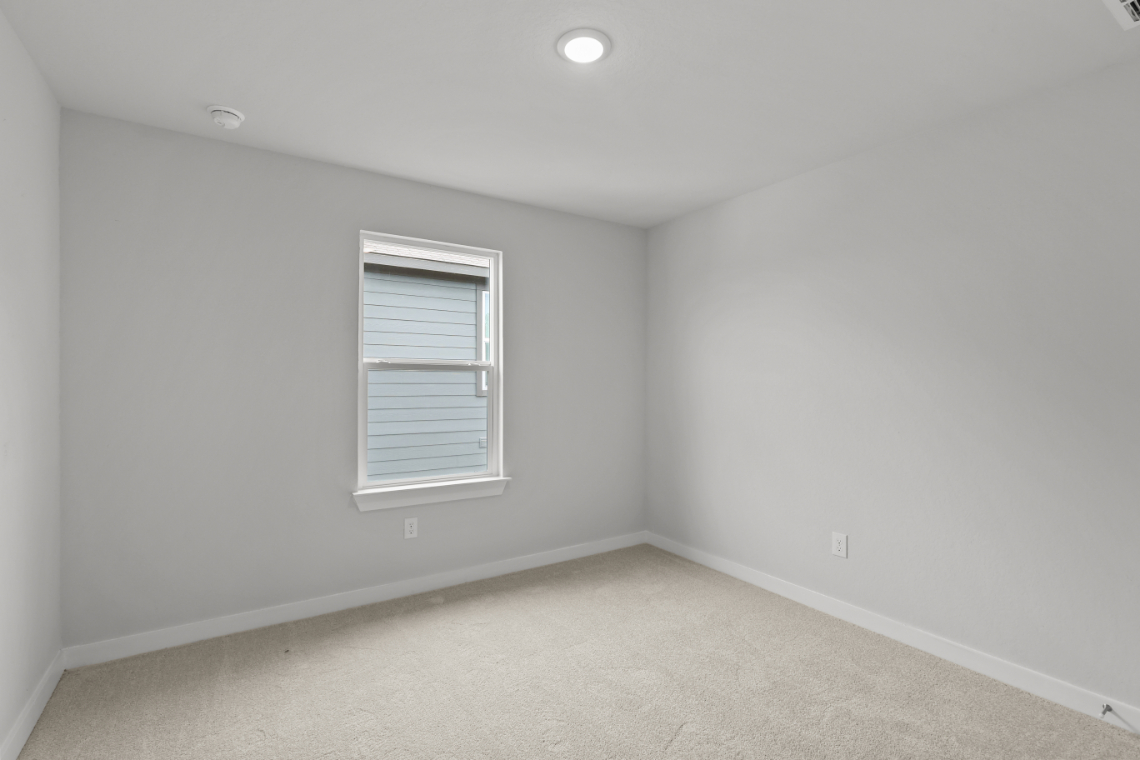 A room with a window and a carpet.