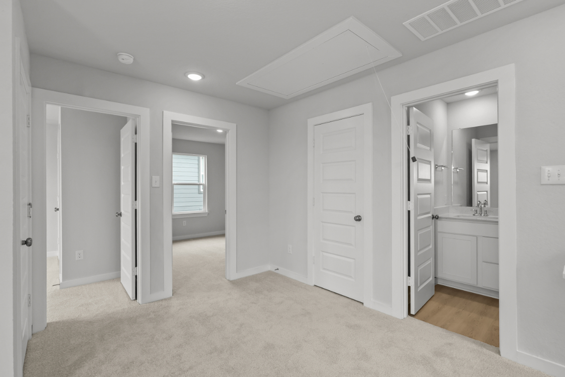 A bathroom with white cabinets.