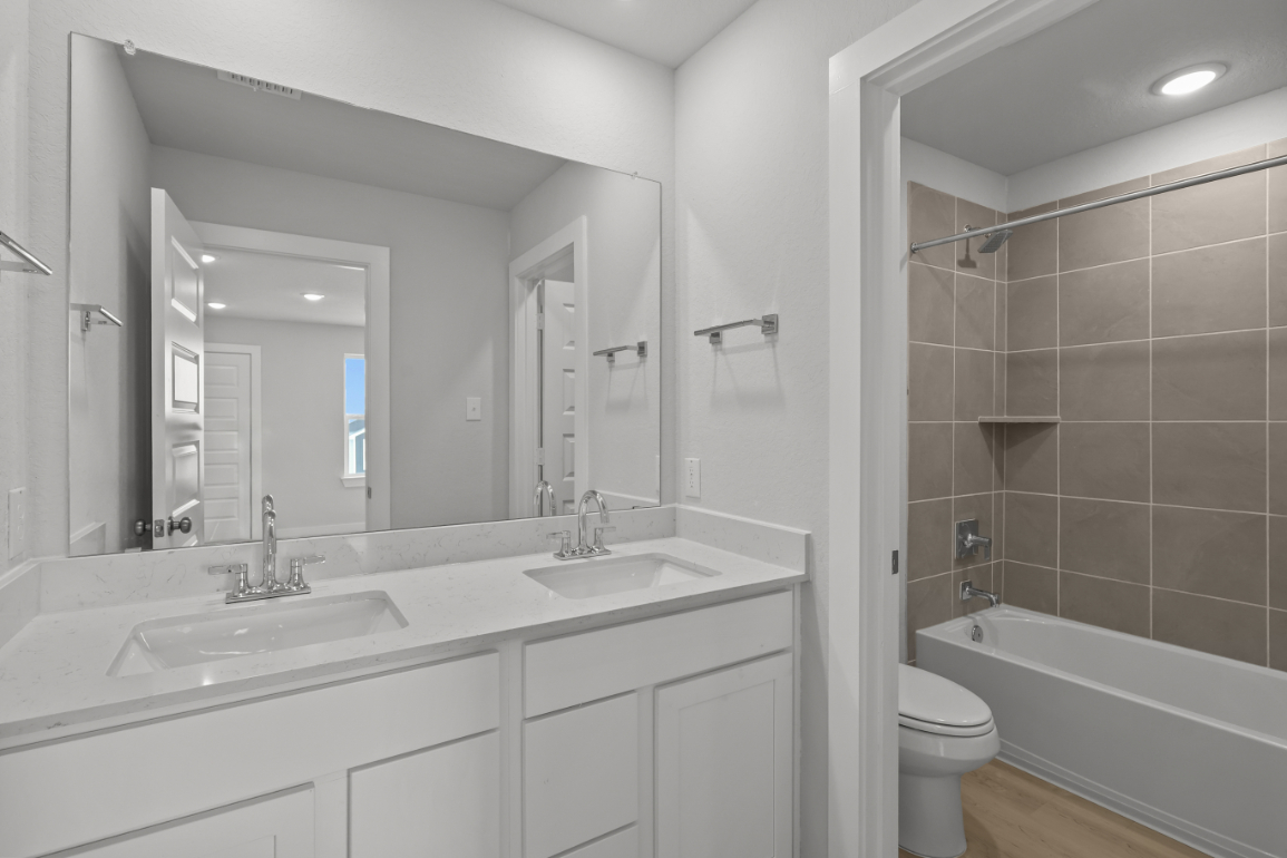 A bathroom with a tub sink and toilet.