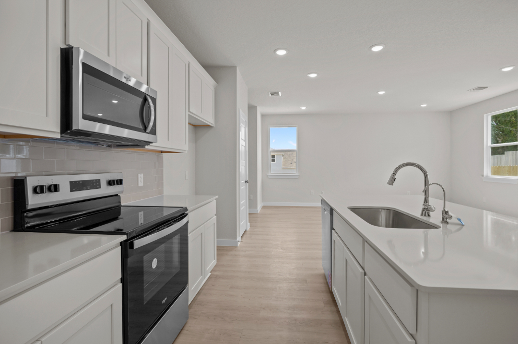 A kitchen with white cabinets.