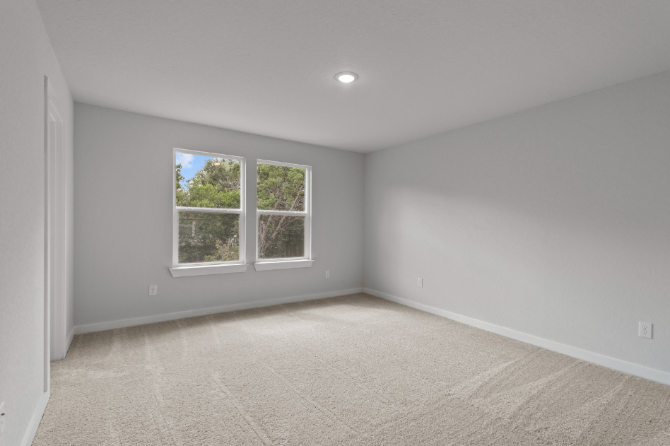 A room with a window and a white wall.