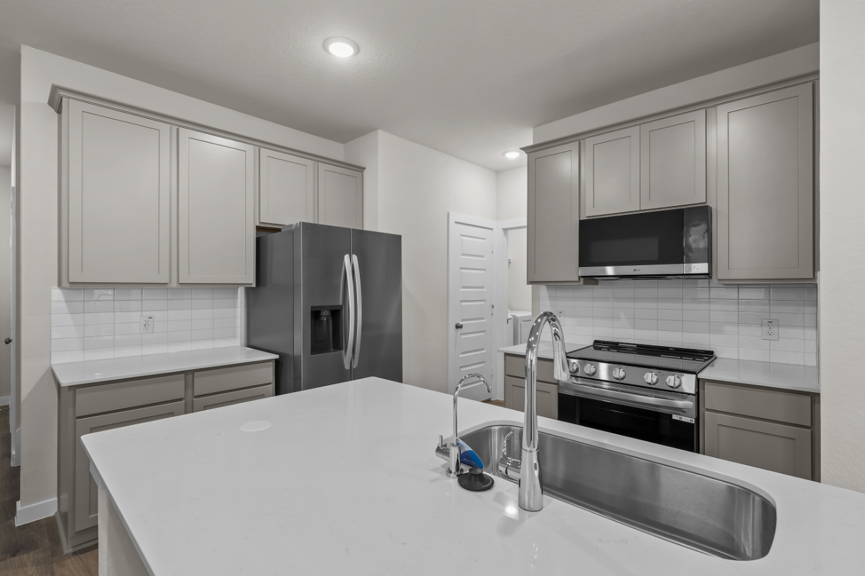 A kitchen with white cabinets.