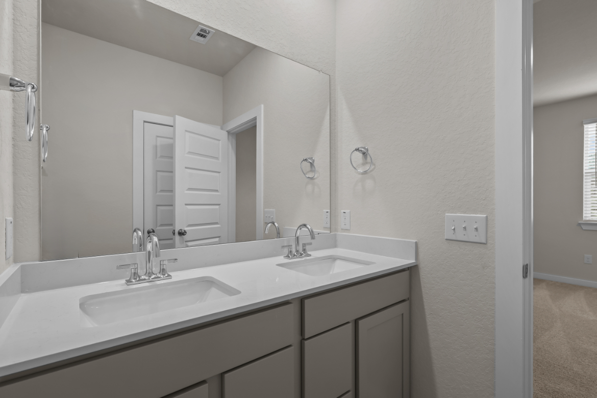 A bathroom with a large mirror.