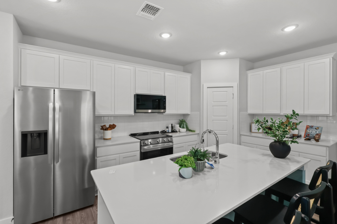 A kitchen with white cabinets.