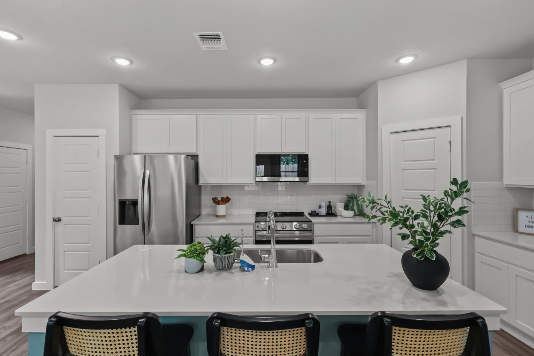 A kitchen with white cabinets.