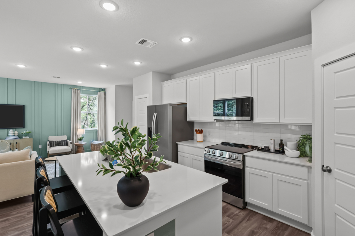A kitchen with white cabinets.