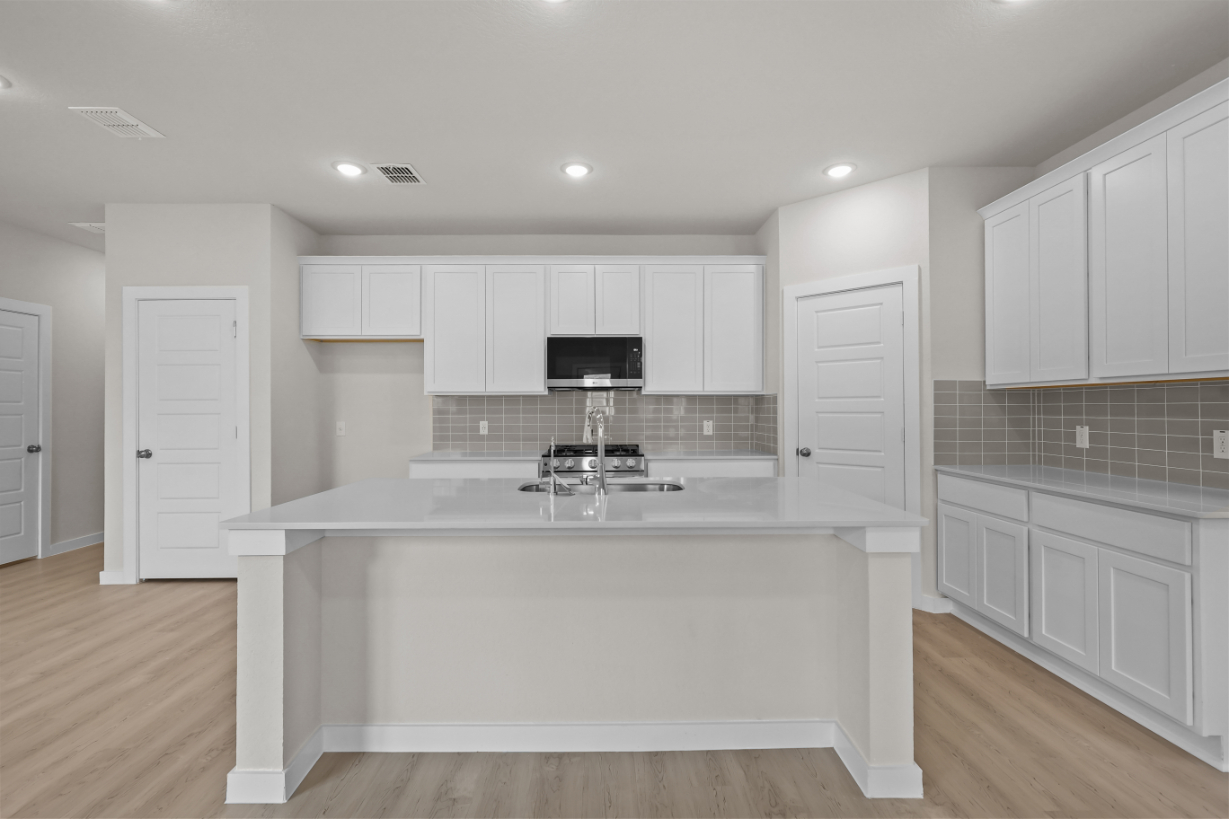 A kitchen with white cabinets.
