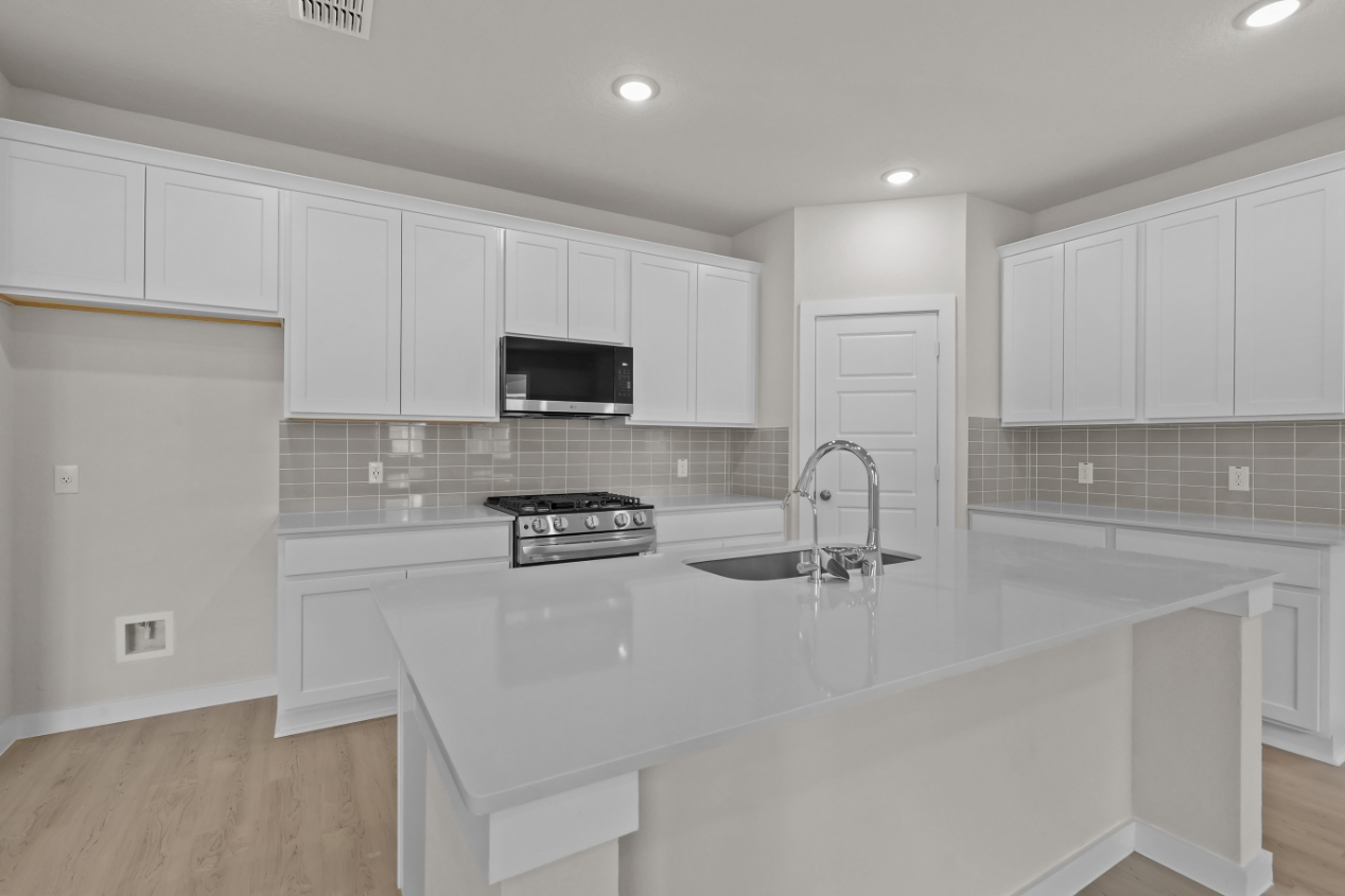 A kitchen with white cabinets.