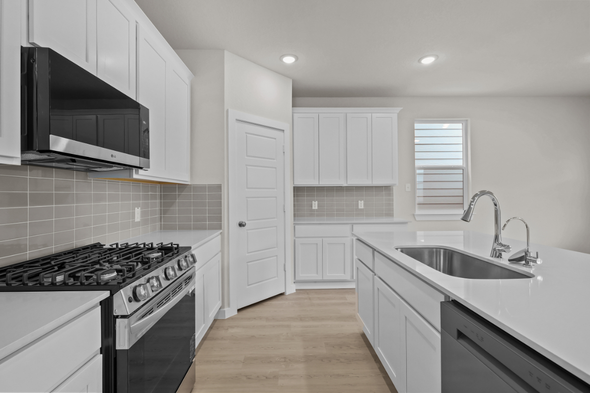A kitchen with white cabinets.
