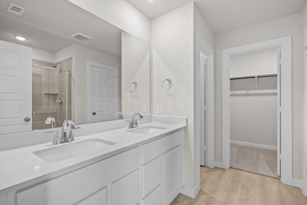 A bathroom with white cabinets.