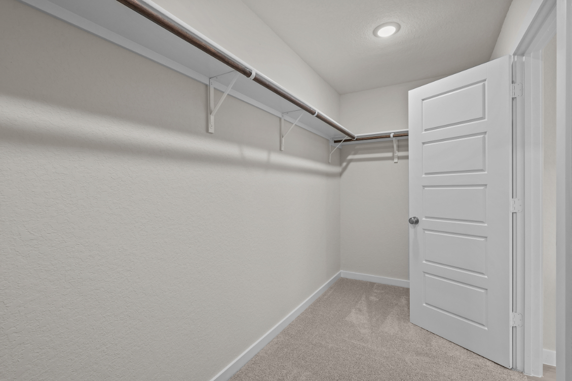 A white hallway with a white door.