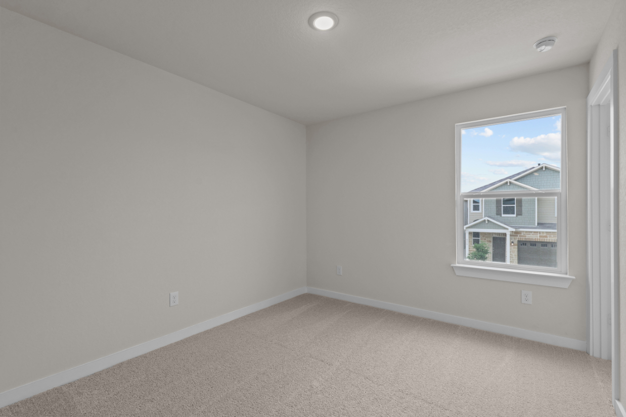 A room with a window and a carpet.