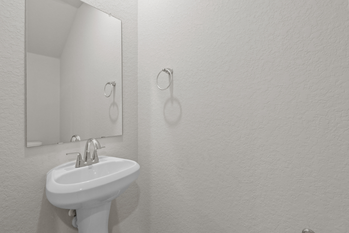 A bathroom with a mirror and sink.