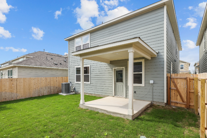 A house with a fence and a yard with a wood fence.