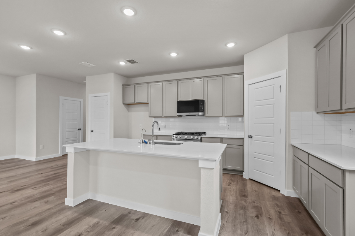 A kitchen with white cabinets.
