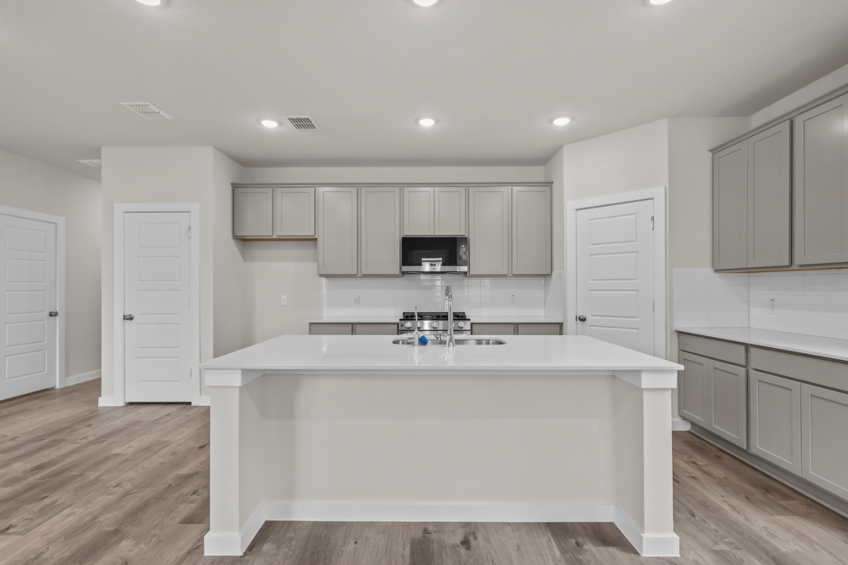 A kitchen with white cabinets.