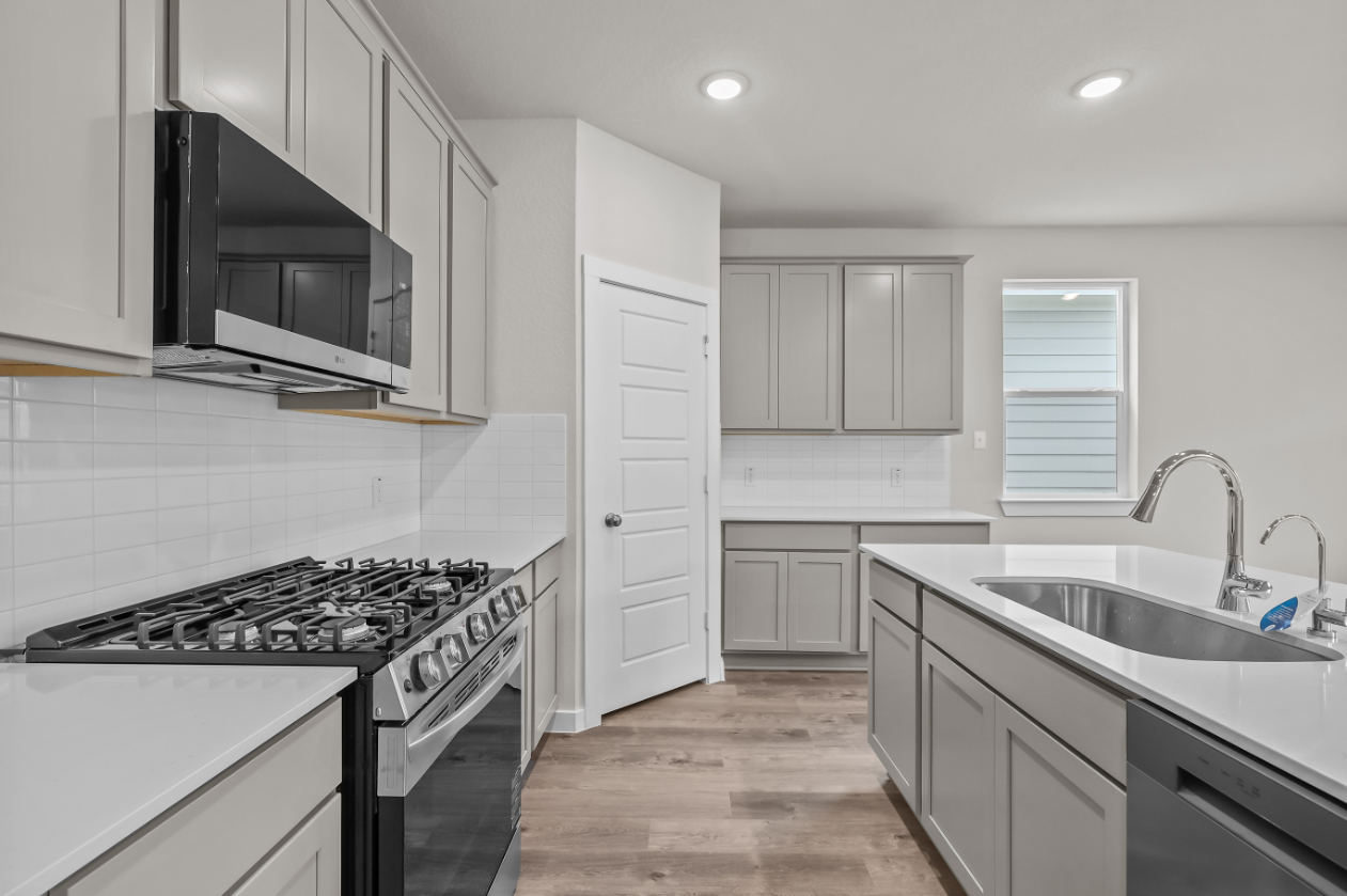 A kitchen with white cabinets.