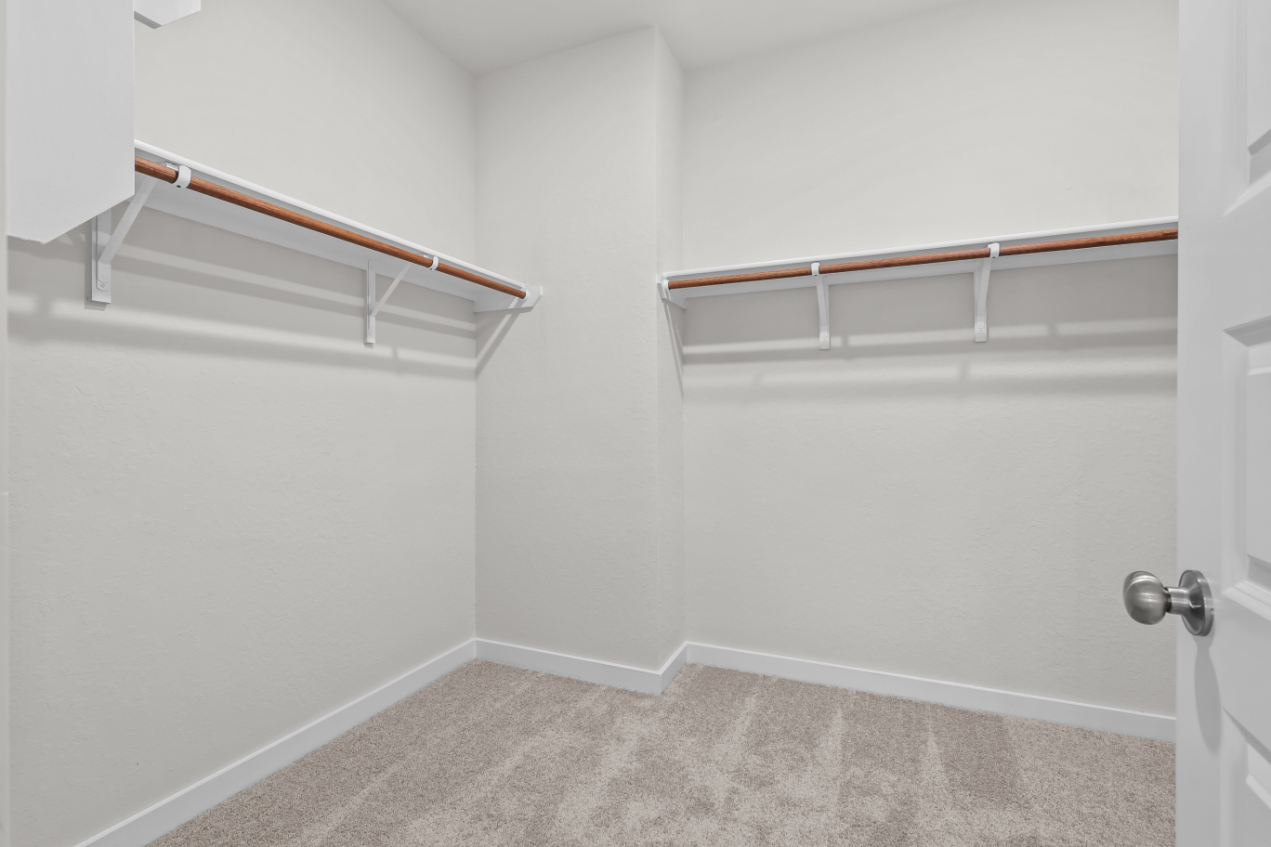 A white room with a white wall and a metal bar.