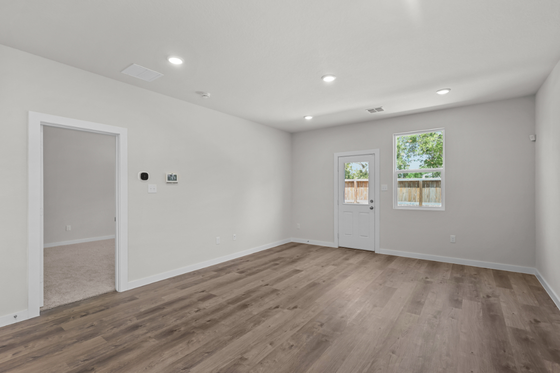 A room with a wood floor and white walls.