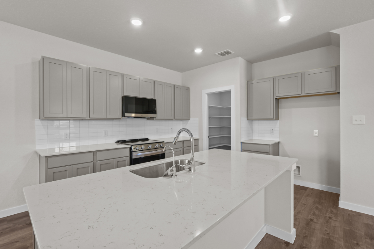 A kitchen with white cabinets.