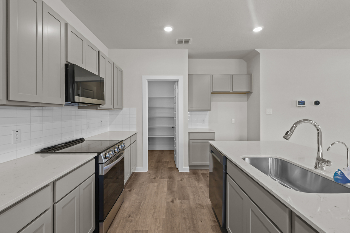 A kitchen with white cabinets.