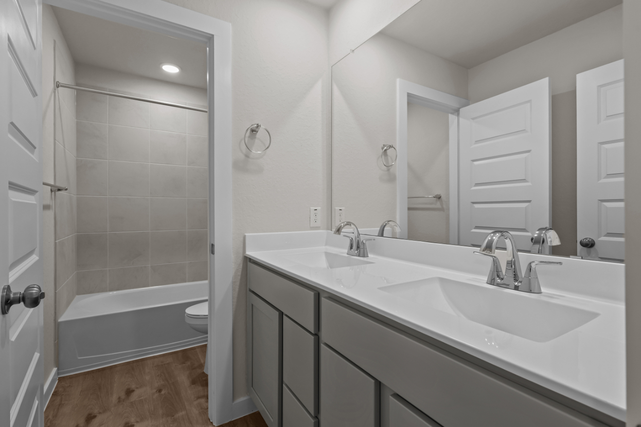 A bathroom with a sink and a shower unit.