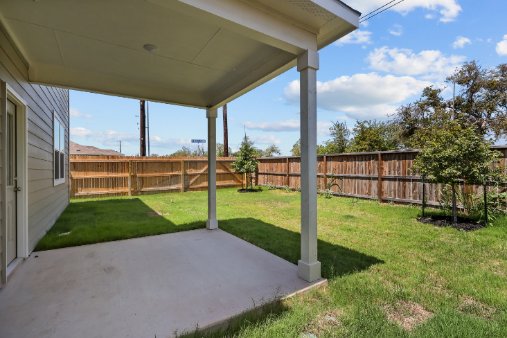A backyard with a covered patio.