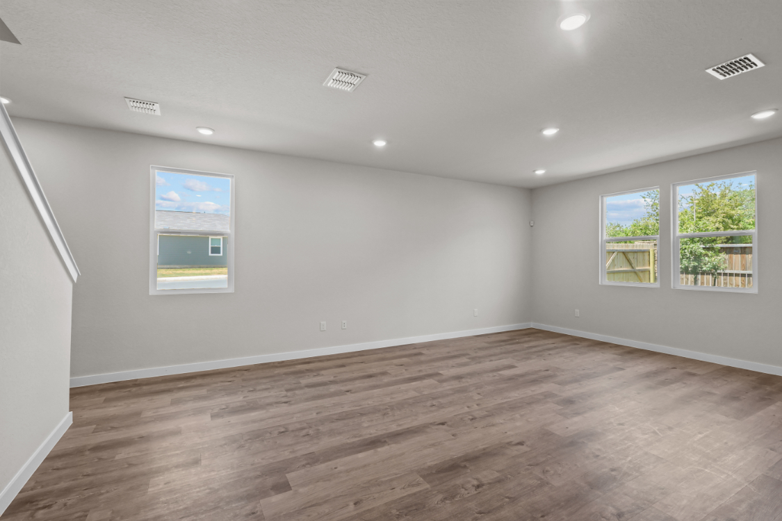 A room with a wood floor and windows.