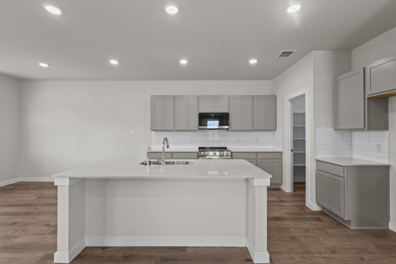 A kitchen with white cabinets.