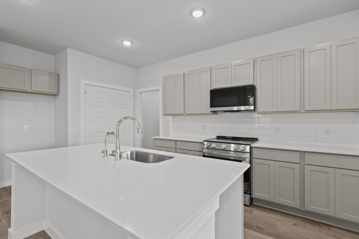A kitchen with white cabinets.