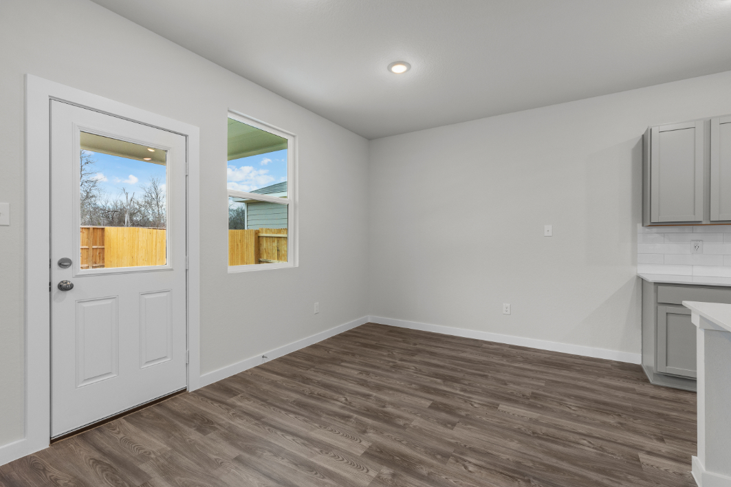 A room with a wood floor and white walls.