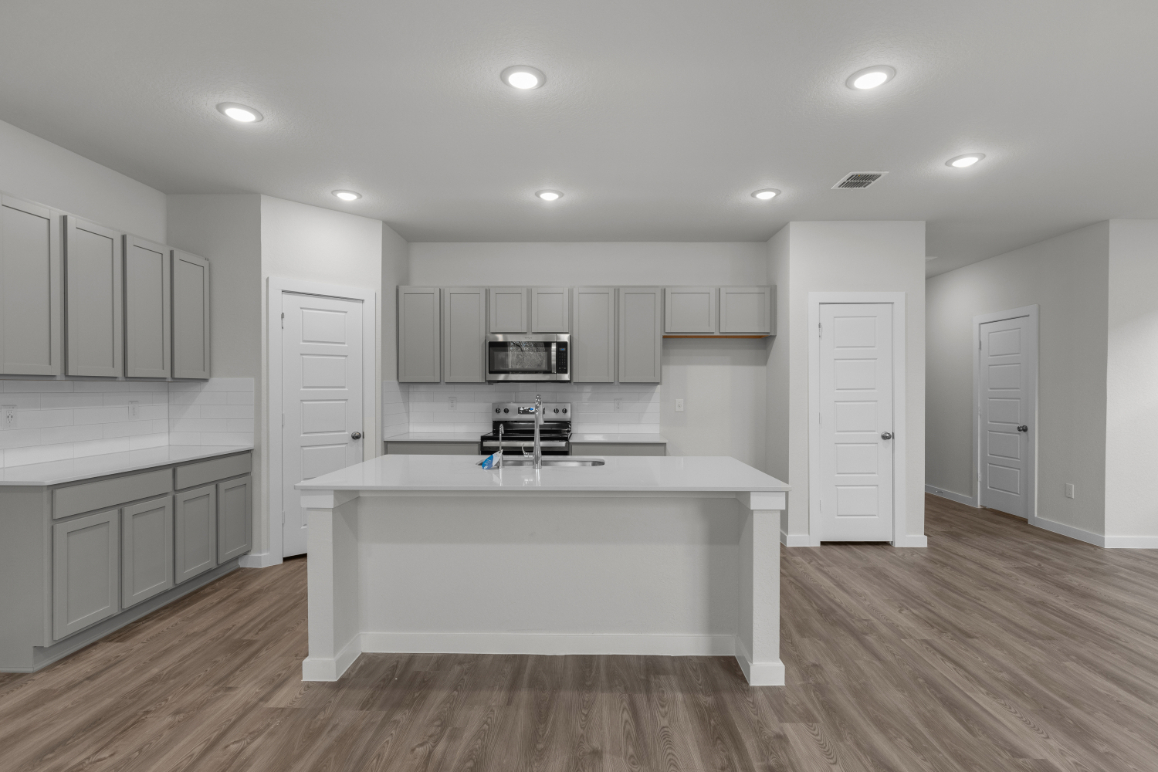 A kitchen with white cabinets.