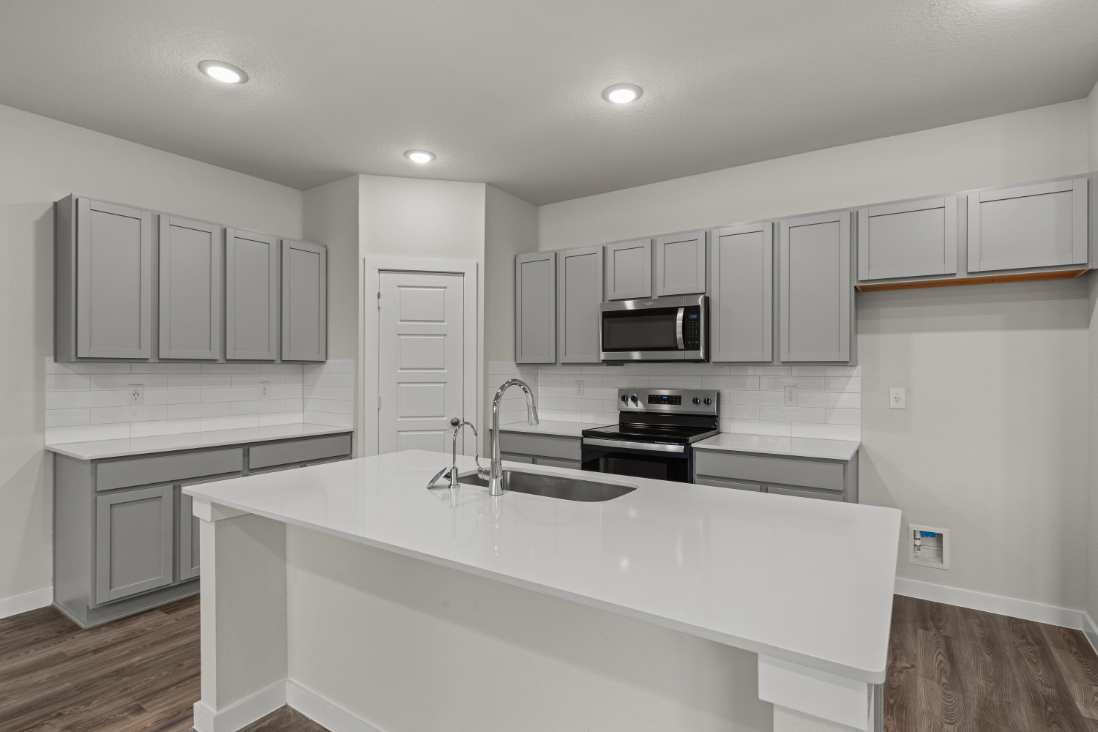 A kitchen with white cabinets.