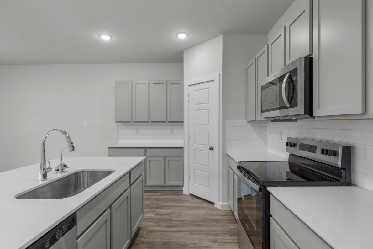 A kitchen with white cabinets.
