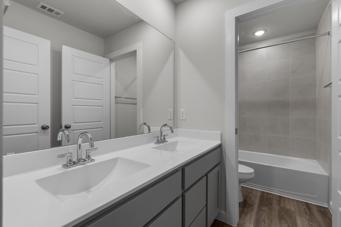 A bathroom with a sink and a shower unit.