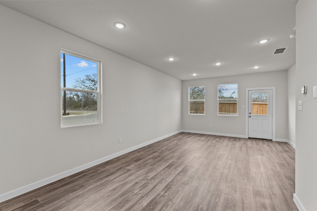 A room with a wood floor and windows.