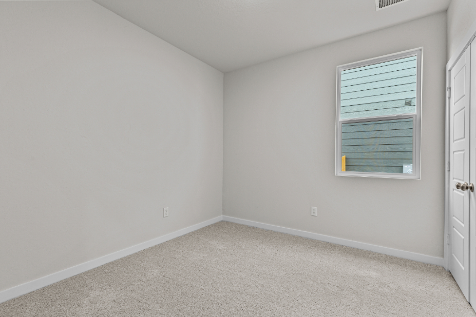 A room with a window and a carpet.