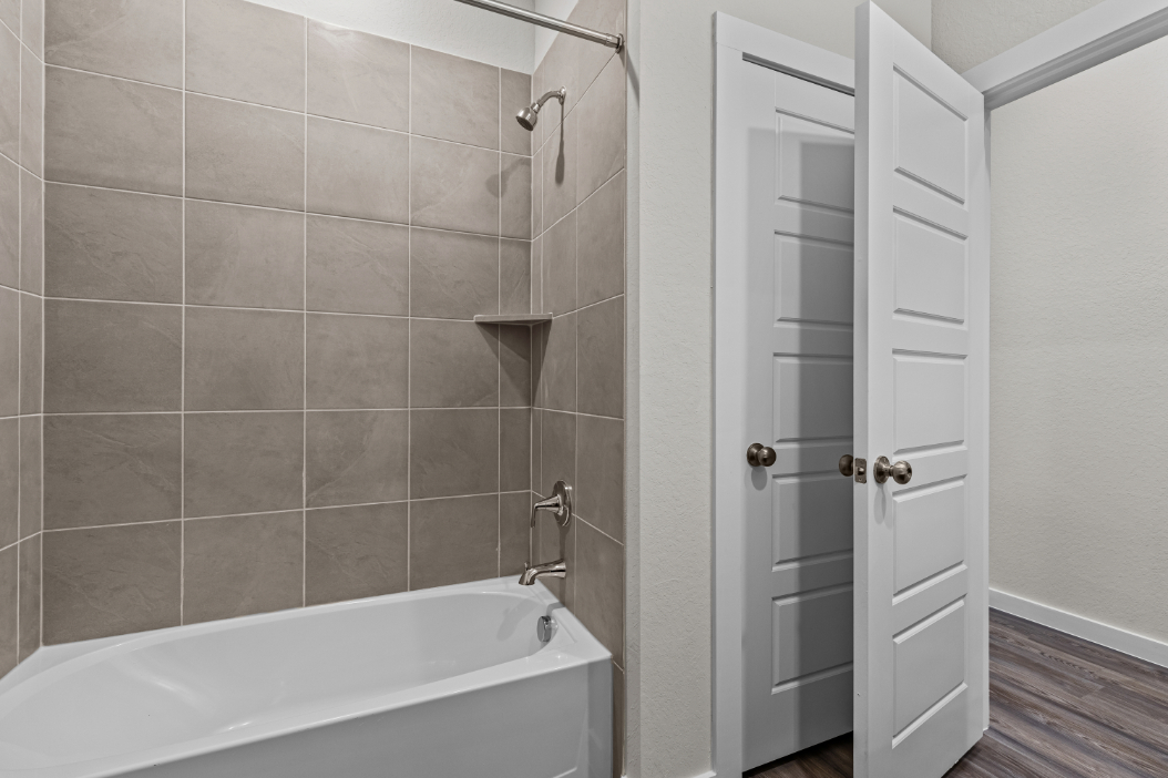 A bathroom with a bathtub and shower.