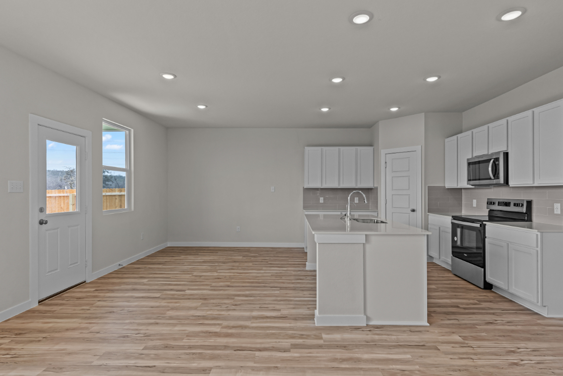 A kitchen with white cabinets.