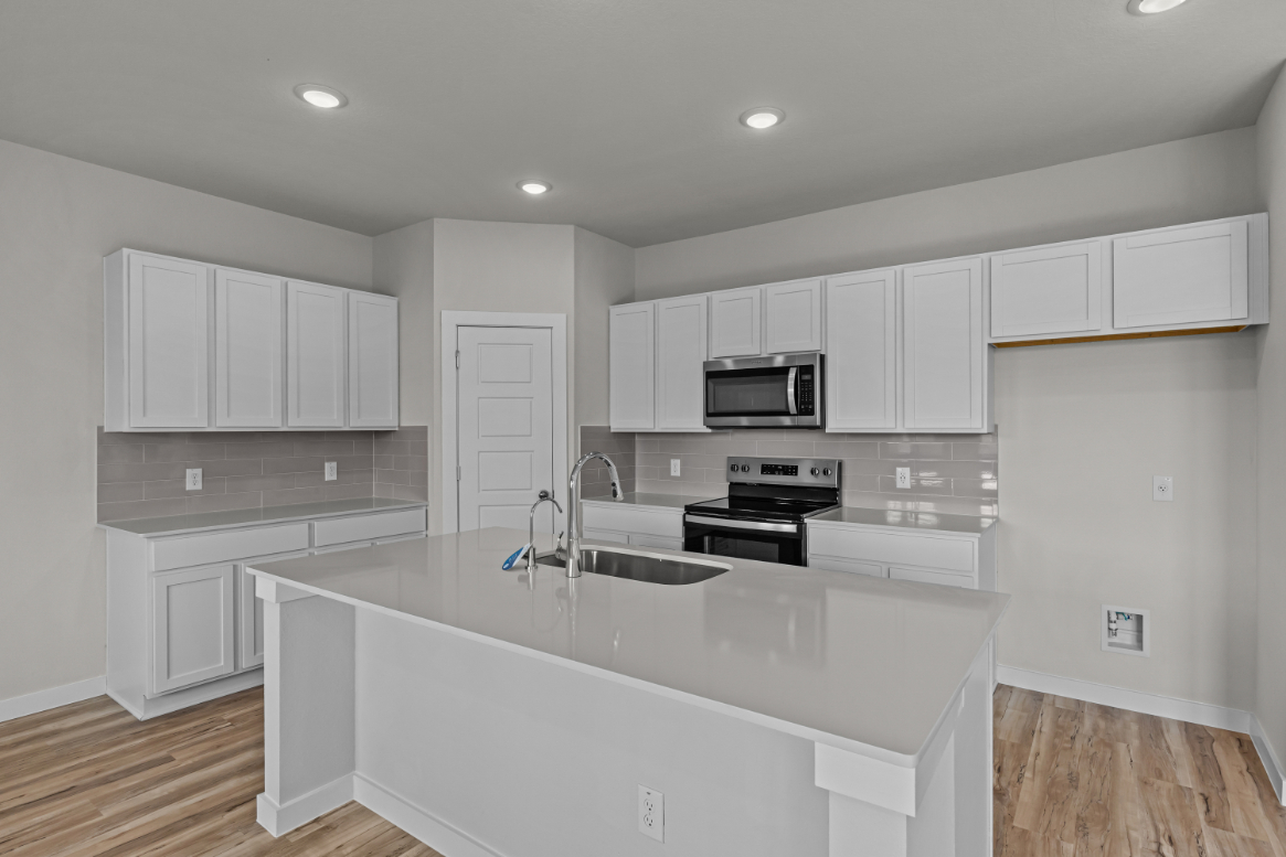 A kitchen with white cabinets.