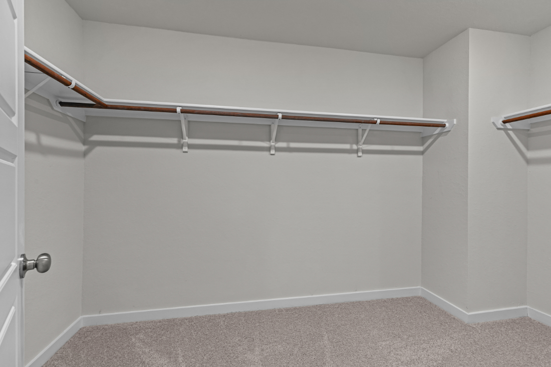 A white wall with a metal bar.