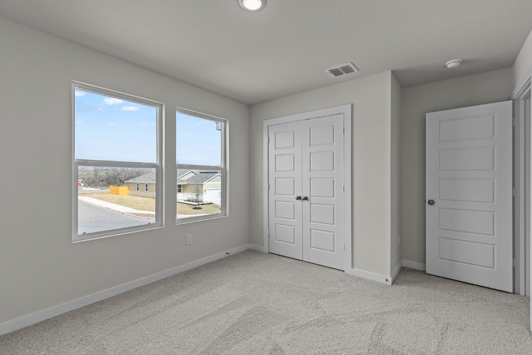 A room with a window and a door with a view of the city.