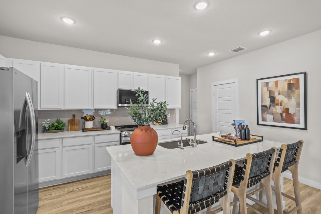 A kitchen with white cabinets.
