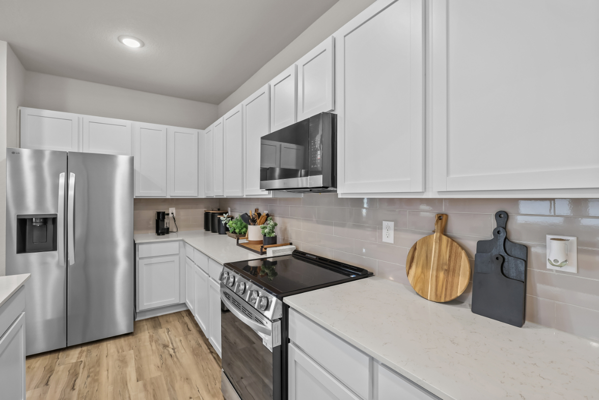 A kitchen with white cabinets.