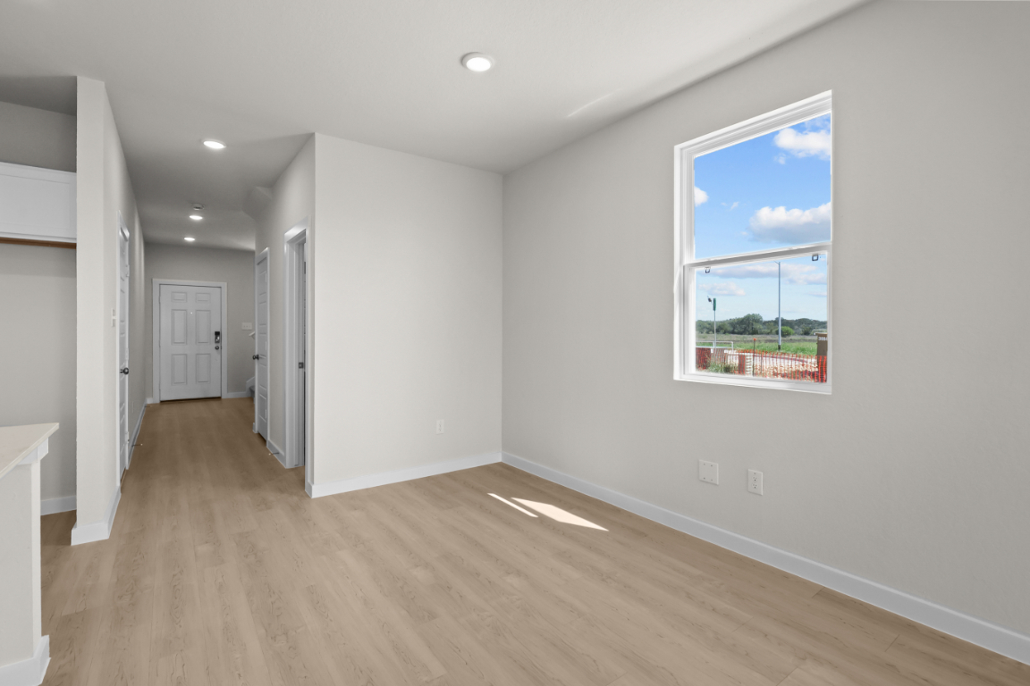 A room with a window and a wood floor.