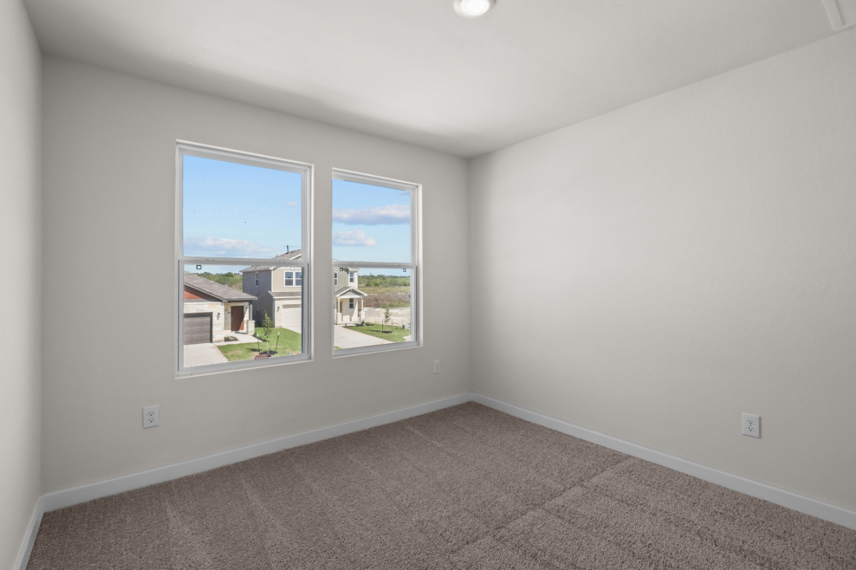 A room with a window and a carpet.